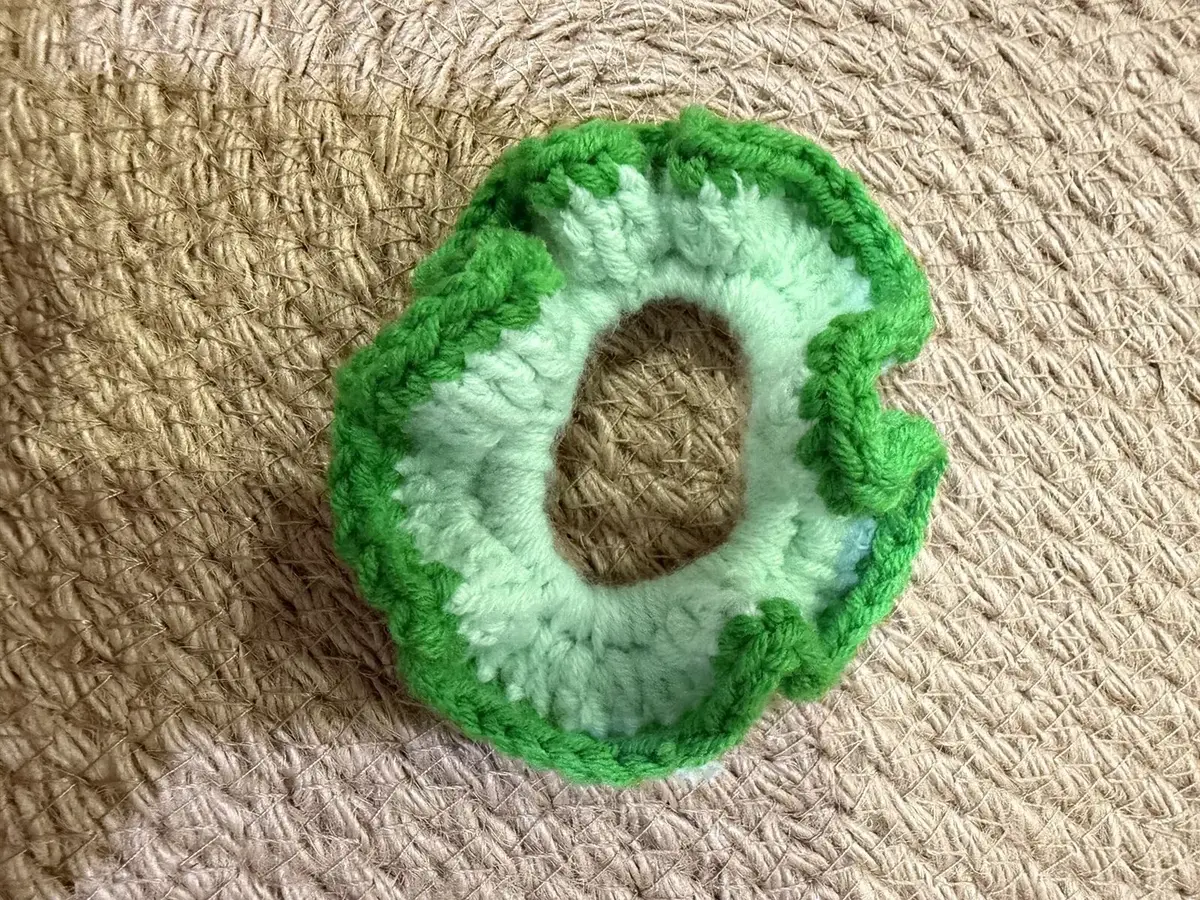 A handmade ruffle scrunchie in mint with a green edge.