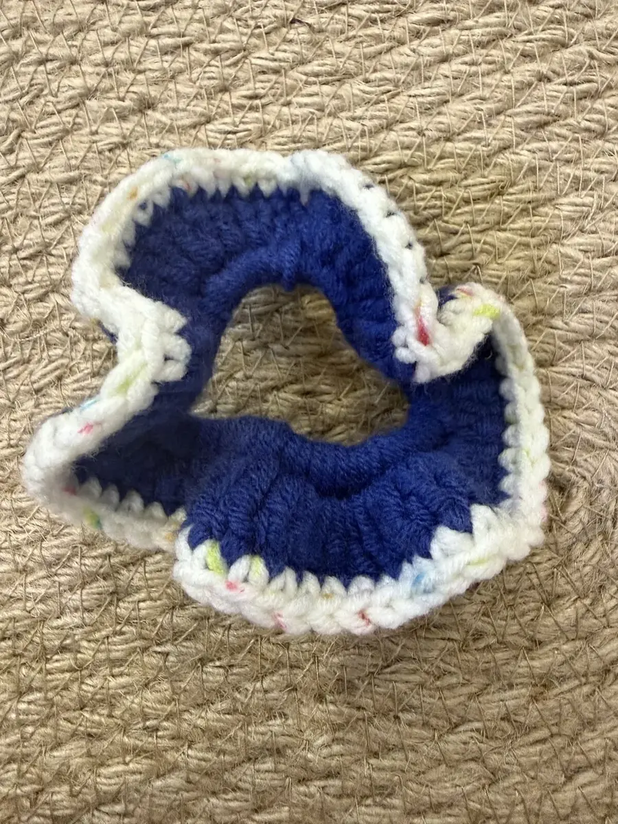 A handmade ruffle scrunchie in navy with a cream confetti edge.