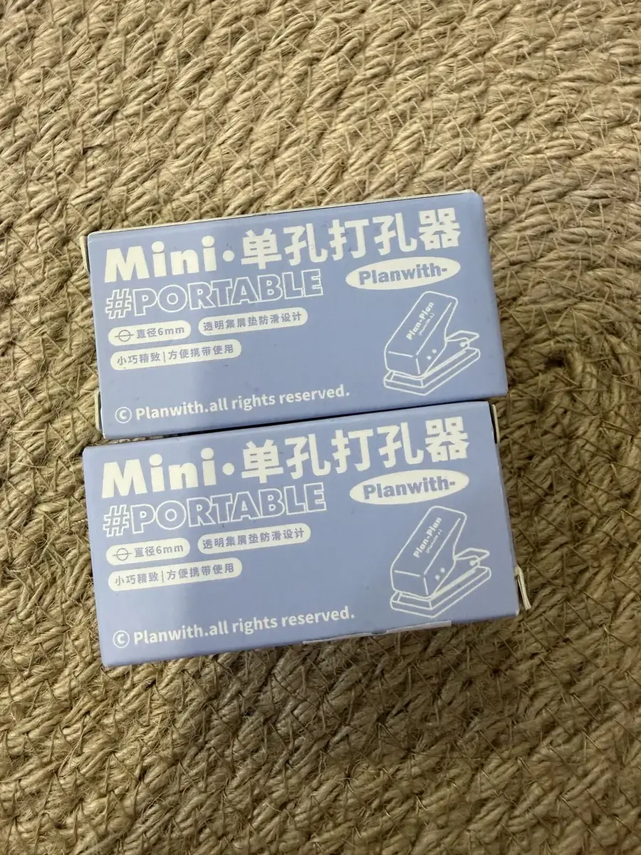 Two mini one-hole punchers in their boxes.