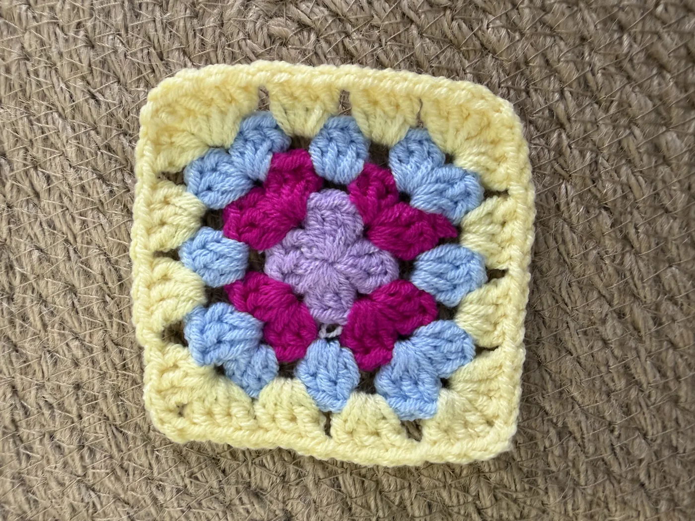 A crochet granny square in blue, red, yellow and green.